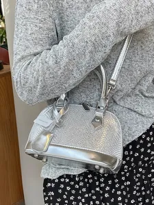 Silver shell-shaped handbag with snake pattern texture and adjustable shoulder strap