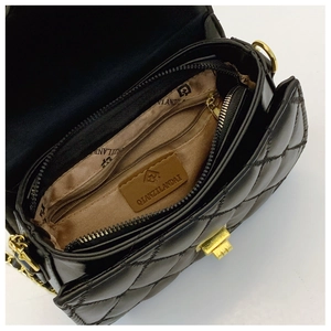 Interior view of black quilted shoulder bag featuring multiple compartments and lining