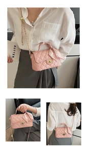 Detail of pink quilted handbag with chain strap, gold lock, and decorative handle scarf