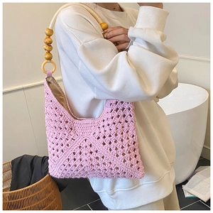 Pink bohemian woven tote bag detail showing hollow knit texture and wooden bead handles