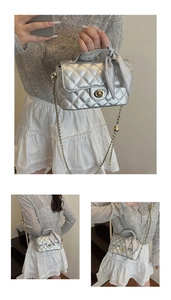 Detail of silver quilted chain bag with ribbon decor and rotating metal lock