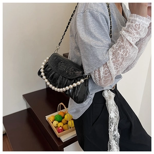 Détail du sac nuage plissé noir brillant avec perles blanches et bandoulière chaîne