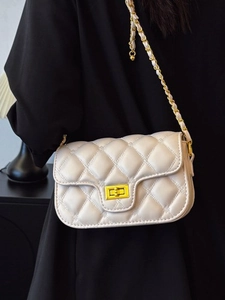 Quilted crossbody bag with gold chain strap and square metal lock shown in a side view