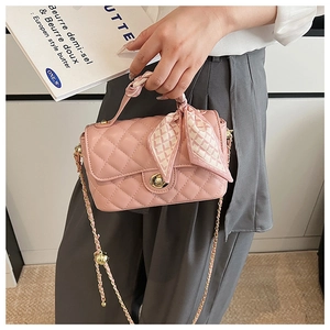 Pink quilted leather bag with gold hardware and decorative scarf on handle detail