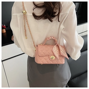 Pink quilted chain crossbody bag featuring a silk scarf wrapped handle shown on model
