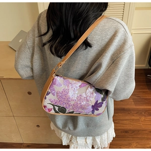 Detail of bohemian sequin embroidery and brown leather strap on retro shoulder bag