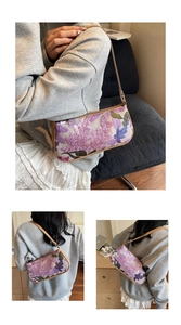 Close-up of floral sequin embroidery and brown leather strap on vintage baguette bag