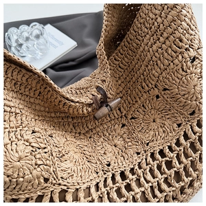 Close-up of woven tote bag texture featuring round patterns and a vintage wooden buckle