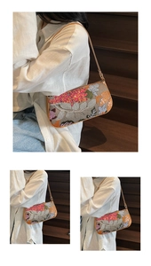Detail of vintage baguette bag featuring colorful floral embroidery and camel strap