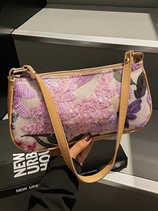 Chic retro handbag with floral sequins and camel leather strap in a lifestyle setting
