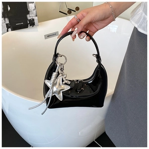 Detail of black patent leather hobo bag with silver star and balloon dog charms
