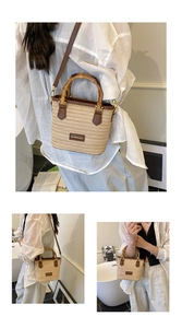 Detail of woven straw bucket bag featuring bamboo handle and brown leather trim