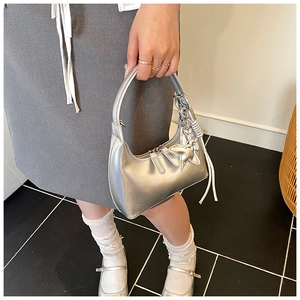 Silver metallic crescent bucket bag styled with a star charm and elegant tassel detail