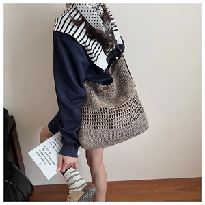 Detail of a brown woven hollow-out tote bag featuring a wooden toggle button closure