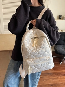 White quilted puffer backpack with heart patterns and front zipper pocket for women