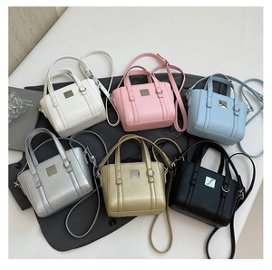 Dettaglio di mini borse a secchiello in bianco, rosa, blu, argento, oro e nero classico