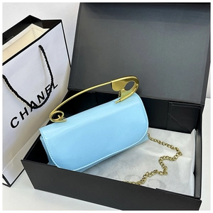 Détail du sac en cuir verni bleu clair avec poignée épingle dorée et bandoulière chaîne