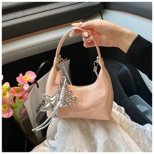 Pink patent leather hobo bag with silver chain charms shown in a lifestyle car setting