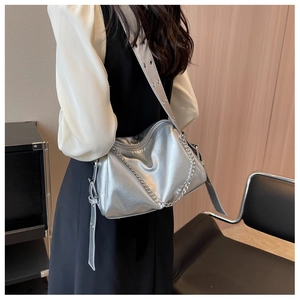 Détail du sac bandoulière argenté métallisé avec chaîne et texture en cuir lisse