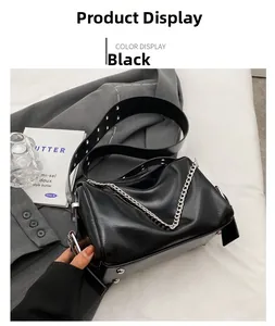 Détails du sac seau en cuir noir avec grosse chaîne argentée et picots de protection