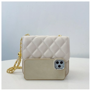 Détail d'un mini sac matelassé crème avec chaîne présenté à côté d'un smartphone
