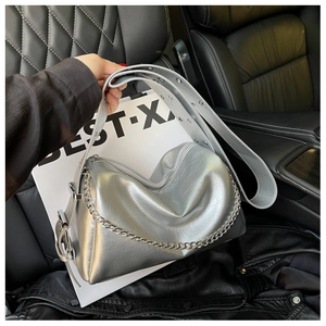 Détail du sac argenté métallisé avec chaîne et bandoulière à œillets sur cuir