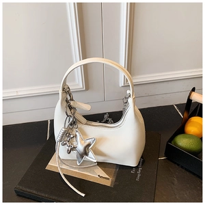 Detail of cream crescent hobo bag with silver chain and star charm on display