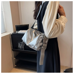 Détail du sac bandoulière argenté avec chaîne décorative et large sangle ajustable