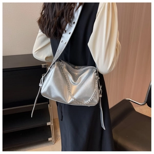 Détail du sac bandoulière argenté métallisé avec chaîne et larges œillets sur la sangle