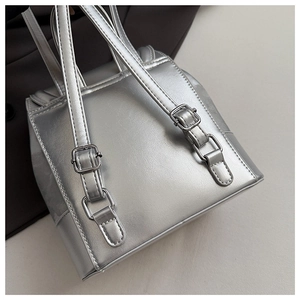 Close-up of adjustable silver shoulder straps and metallic texture on a mini backpack