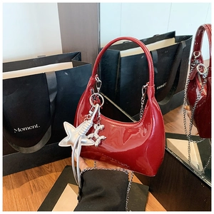 Detail of dark red patent leather hobo bag with silver star and balloon dog charms