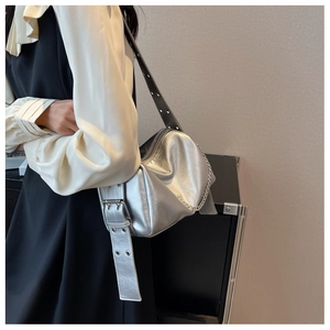 Détail du sac bandoulière en cuir argenté avec chaîne et bandoulière à œillets