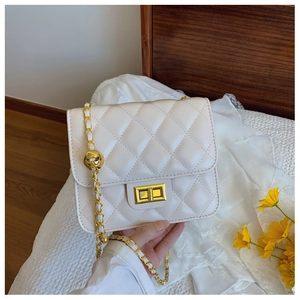 Détail du sac bandoulière blanc matelassé avec chaîne dorée et perle de réglage