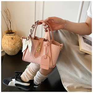 Détails du sac seau rose tressé avec foulard en soie et fermoir doré chic