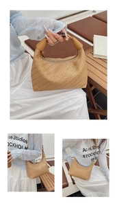 Close-up of beige woven texture half-moon handbag with metal zipper and leather handle