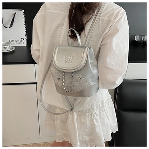 Detail view of silver chain backpack with cartoon dog print and embossed flap design