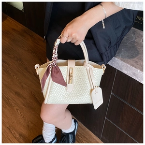 Détail du sac à main blanc tressé avec foulard en soie et boucle en métal doré