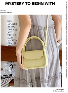 Detail of a pastel yellow mini crossbody bag with a round handle and flap closure