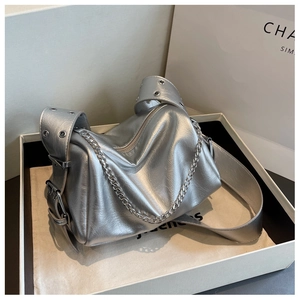 Gros plan sur un sac bandoulière argenté plissé avec chaîne et sangle à œillets en boîte