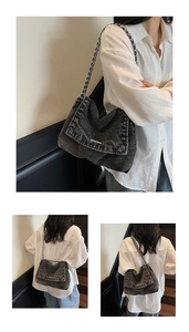 Detail view of washed denim tote bag with chain strap and vintage metal fastener