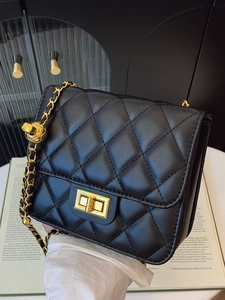 Sac bandoulière élégant en cuir matelassé noir avec chaîne dorée et breloque boule ajustable