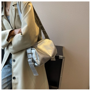 Détail du sac bandoulière argenté métallisé avec chaîne épaisse et bandoulière à œillets