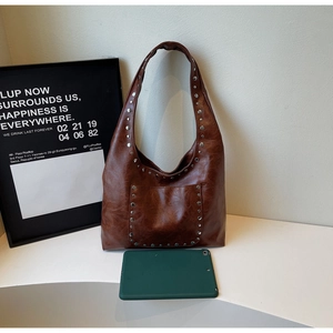 Détail du sac Hobo marron vintage avec rivets argentés et texture cuir ciré