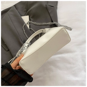 Minimalist white faux leather bucket bag with silver chain strap and top handle
