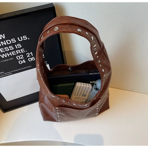 Vue de dessus montrant l'intérieur spacieux d'un sac cabas marron orné de clous argentés
