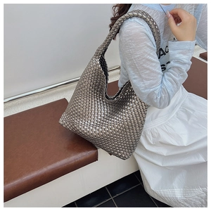 Detail of silver metallic woven tote bag with intricate leather-like grid texture