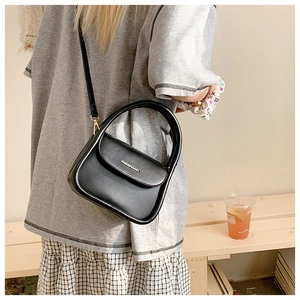 Detail of black matte leather square bag with gold FASHION & BAGS lettering and shoulder strap