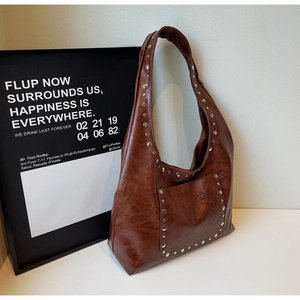 Détail du sac cabas vintage marron avec rivets métalliques et texture cuir ciré
