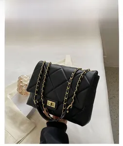Détail du sac matelassé noir avec bandoulière en chaîne dorée et fermoir pivotant