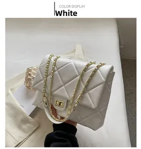 Détail du sac matelassé blanc avec chaîne dorée et fermoir rotatif en métal carré